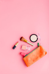 Women desk with decorative cosmetics for make up on pink background flat lay space for text