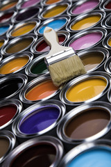 Paintbrush on cans with color