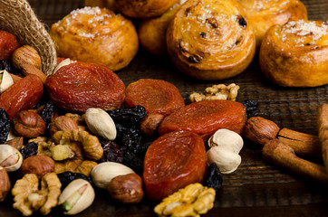 Nuts, dried fruits, pistachios and homemade cookies are scattered from the bag on the table