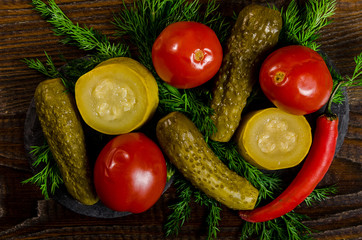 pickles: cucumber tomatoes, zucchini and herbs scattered on a wooden background