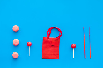 Gift concept. Sweets, paper bag for gift on blue background top view mock up