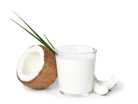Glass of coconut milk and fresh nut on white background