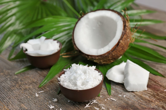 Bowl with fresh coconut flakes on wooden background