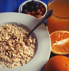 Breakfast with oatmeal and orange juice on blue wooden backgroun