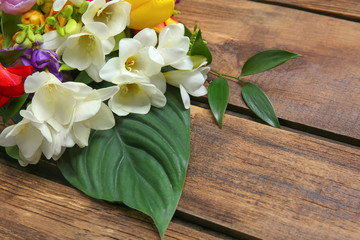Beautiful freesia bouquet on wooden background