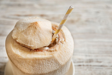 Fresh coconut drink in nut on wooden background