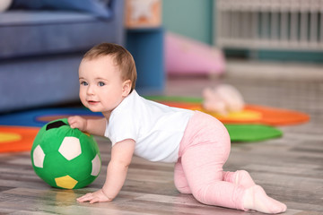 Cute baby playing with ball at home