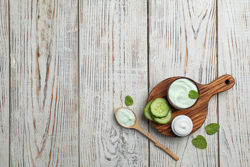 Composition with body cream in jars on wooden background, top view