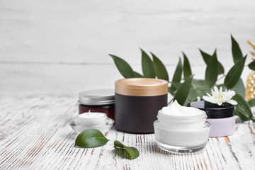 Composition with body cream in jars on light background