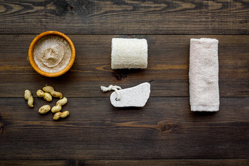 Beauty set with natural peanut scrub for spa on wooden background top view mockup