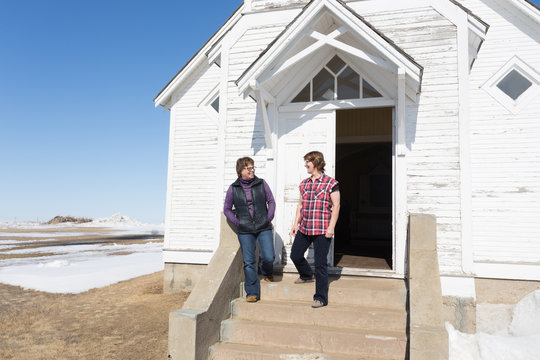 Two Women Walking Out Of A Church Laughing