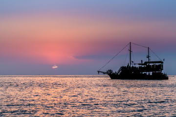 Fototapeta premium Pirate ship in the ocean during sunset