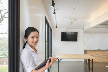 Portrait of smiling pretty young business woman on workplace, Calculating the cost of postage of a small package, Small business enterprise concerns for online Shopping