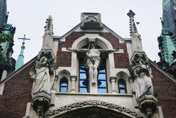 Fototapeta na wymiar Baroque and Gothic architecture. Crucifixion of Jesus on facade of the building. St. Olga and Elizabeth church in Lviv.