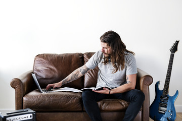 Obraz premium Hipster Caucasian rocker working on a laptop
