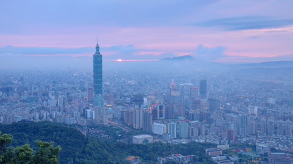 Obraz premium Aerial panorama of busy Taipei City at moody dusk with Taipei 101 in XinYi commercial area, Tamsui River and downtown area in twilight with beautiful rosy afterglow shining through heavy clouds 