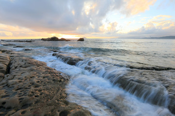 Beautiful rocky beach illuminated by the golden rays of morning sunlight at Yehliu Coast, Taipei, Taiwan ~ A romantic sunrise scenery of Yehliu Geopark with dramatic dawning sky (Long Exposure)