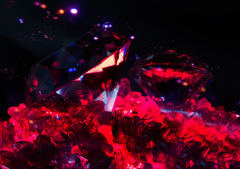 Photo of a rich glowing diamonds laying on a red lightened quartz stones with bright sparkles effect on background.