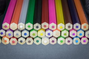 Color pencils of different colors lie on a gray background