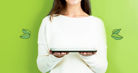 Green Leaves with woman holding a tablet computer