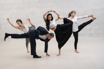 A man and women in office clothes doing yoga