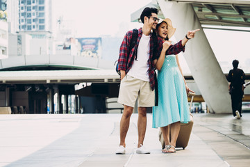 Couple Asian travelers are walking and enjoying vacations on city street. Travel concept