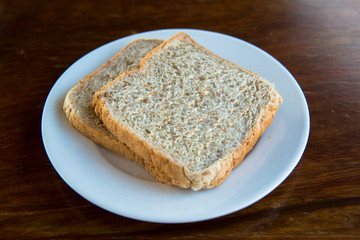 2 slices whole wheat bread, put on a white plate.