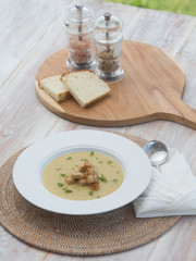 Cream soup on wooden table with bread