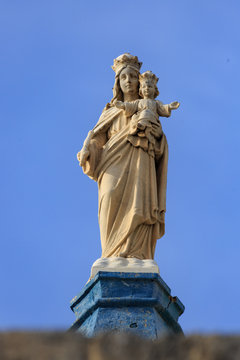 Statue of virgin Mary with child on top