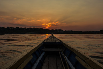Front view of Old fishing boat with golden sunset as a background.