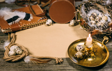 Vintage mock up on rustic wood board. Candlestick, eggs inside nest, notebook, coil of rope, and sheet of paper for text.