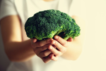 Woman in white T-shirt holding broccoli in hands. Copy space. Healthy clean detox eating concept....