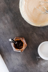 Chestnut, caramel puree jar and a bowl with cream cheese filling. Dark food photography concept. Vertical, overhead
