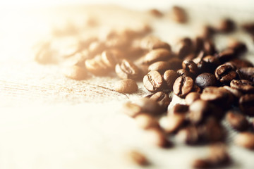 Coffee beans on light wooden background with copyspace for text. Coffee background, food frame, texture concept. Banner