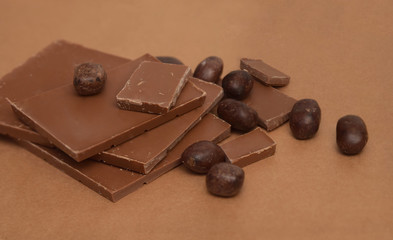 Chocolate Bar and Chocolate Pieces overBrown Background. Sweet Dessert. top view.