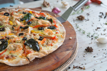 Big tasty pizza with seafood shrimp on a wooden table