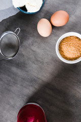 Baking ingredients, preparing dough on dark background from above. Copy space, vertical