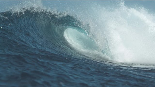 SLOW MOTION, CLOSE UP: White water droplets fly everywhere as Cloudbreak wave crashes. Beautiful tube wave breaks and splashes furiously, sending countless drops of crystal clear sea water flying.