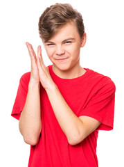 Emotional portrait of caucasian cunning teen boy wearing red t-shirt. Funny child conceived trick, isolated white background. 