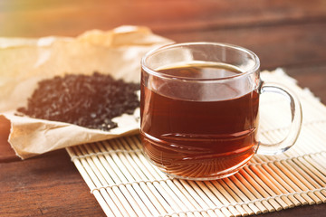 Cup with Tea, Dried Tea Leaves on Kraft Paper on a Wooden Table