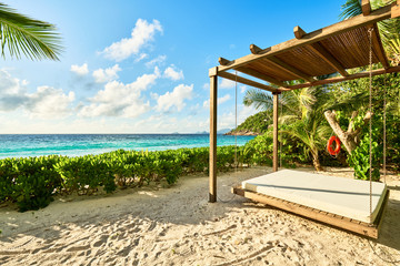 Luxury wooden lounge beds on a beautiful mahe beach, seychelles