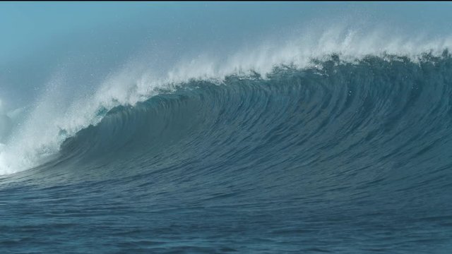 SLOW MOTION CLOSE UP: Cinematic ocean wave crashes and sprays the surroundings on a fresh summer morning. Massive emerald tube wave splashes violently, showing the power of nature. Awesome ocean swell