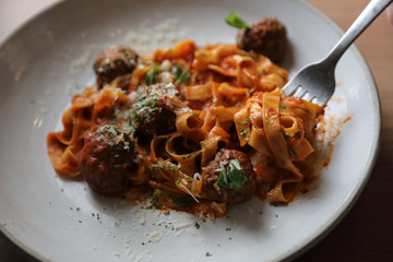 Spaghetti pasta with beef meatballs and tomato sauce on wood background . italian food