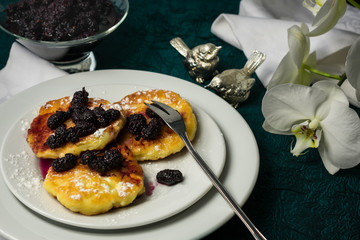 Cottage cheese pancakes with mulberry jam and berries. Homemade, useful delicious breakfast and a flower on the table