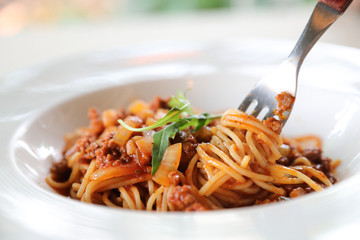 spaghetti Bolognese with minced beef and tomato sauce garnished with parmesan cheese and basil , Italian food