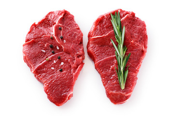 Fresh raw beef steaks, pepper and rosemary isolated on white background.