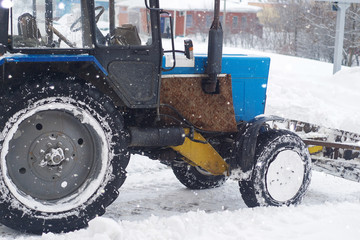 Old wheel loader clearing snow in the city