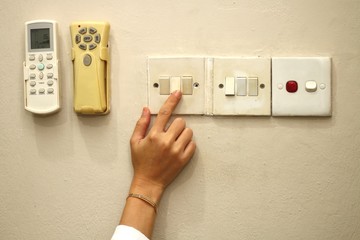 women hand turn on the light switch