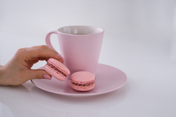 Woman hand hold cup of coffee, cake macaron. Cozy breakfast. Flat lay style.