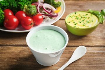 Tasty creamy sauce for fish taco in bowl on wooden table